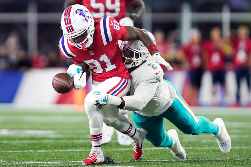 Miami Dolphins linebacker Bradley Chubb, right, strips the ball from the hands of New England Patriots wide receiver Demario Douglas (81) during the first half of an NFL football game, Sunday, Sept. 17, 2023, in Foxborough, Mass. (AP Photo/Steven Senne)