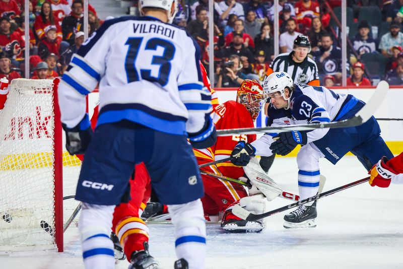 Feb 19, 2024; Calgary, Alberta, CAN; Winnipeg Jets center Sean Monahan (23) scores a goal against Calgary Flames goaltender Jacob Markstrom (25) during the first period at Scotiabank Saddledome. Mandatory Credit: Sergei Belski-USA TODAY Sports