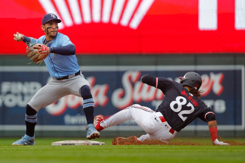 Jun 20, 2024; Minneapolis, Minnesota, USA; Tampa Bay Rays shortstop Jose Caballero (7) forces out Minnesota Twins second baseman Austin Martin (82) and turns the double play in the fifth inning at Target Field. Mandatory Credit: Bruce Kluckhohn-USA TODAY Sports