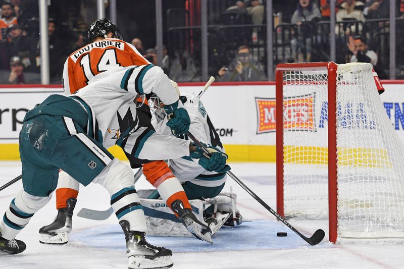 Nov 11, 2024; Philadelphia, Pennsylvania, USA; San Jose Sharks right wing Givani Smith (54) reaches for the puck before it crosses the goal line to save a goal against the Philadelphia Flyers during the third period at Wells Fargo Center. Mandatory Credit: Eric Hartline-Imagn Images