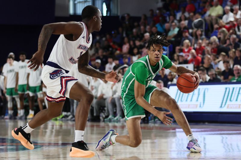 Jan 28, 2024; Boca Raton, Florida, USA; North Texas Mean Green forward Aaron Scott (1) dribbles the basket as Florida Atlantic Owls guard Johnell Davis (1) defends during the first half at Eleanor R. Baldwin Arena. Mandatory Credit: Sam Navarro-USA TODAY Sports