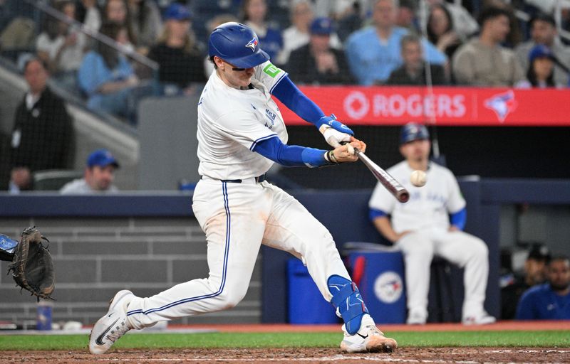 May 17, 2024; Toronto, Ontario, CAN;  Toronto Blue Jays catcher Danny Jansen (9) hits a single against the Tampa Bay Rays in the eighth inning at Rogers Centre. Mandatory Credit: Dan Hamilton-USA TODAY Sports