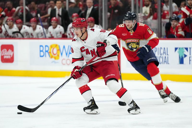 Nov 10, 2023; Sunrise, Florida, USA; Carolina Hurricanes center Martin Necas (88) controls the puck away from Florida Panthers center Steven Lorentz (18) during the first period at Amerant Bank Arena. Mandatory Credit: Jasen Vinlove-USA TODAY Sports