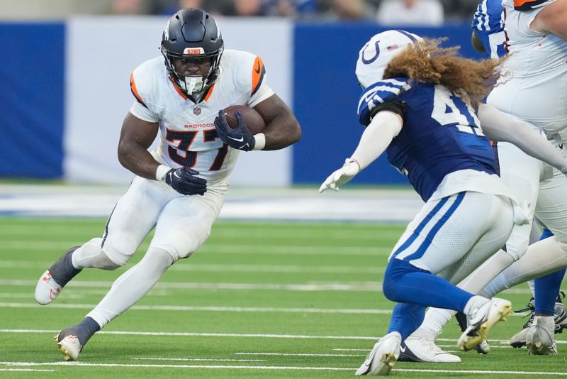 Denver Broncos running back Audric Estime (37) carries the ball against the Indianapolis Colts during the second half of a preseason NFL football game, Sunday, Aug. 11, 2024, in Westfield, Ind. (AP Photo/Darron Cummings)