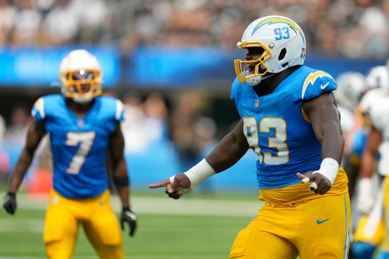 Los Angeles Chargers cornerback Kristian Fulton (7) and defensive tackle Otito Ogbonnia (93) react after a defensive stop against the Las Vegas Raiders during the first half of an NFL football game, Sunday, Sept. 8, 2024, in Inglewood, Calif. (AP Photo/Ashley Landis)