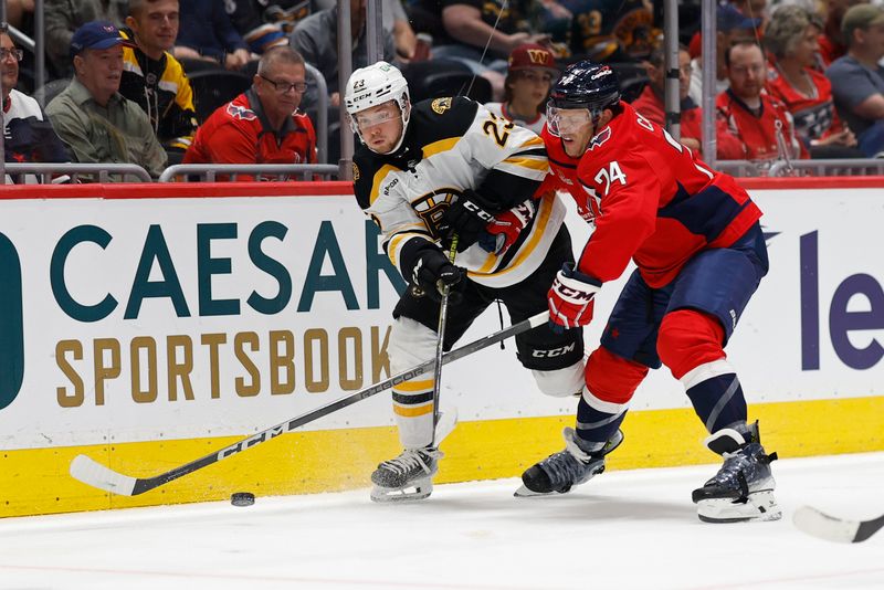 Oct 5, 2024; Washington, District of Columbia, USA; Boston Bruins right wing Fabian Lysell (23) passes the puck as Washington Capitals defenseman John Carlson (74) defends in the second period at Capital One Arena. Mandatory Credit: Geoff Burke-Imagn Images
