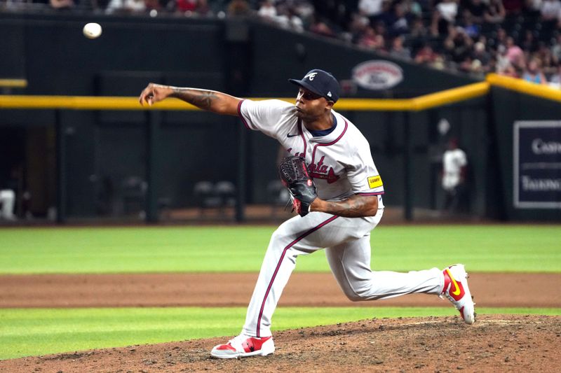 Jul 8, 2024; Phoenix, Arizona, USA; Atlanta Braves pitcher Raisel Iglesias (26) throws against the Arizona Diamondbacks in the tenth inning at Chase Field. Mandatory Credit: Rick Scuteri-USA TODAY Sports