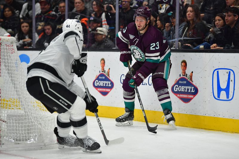 Nov 24, 2023; Anaheim, California, USA; Anaheim Ducks center Mason McTavish (23) controls the puck against Los Angeles Kings defenseman Mikey Anderson (44) during the second period at Honda Center. Mandatory Credit: Gary A. Vasquez-USA TODAY Sports