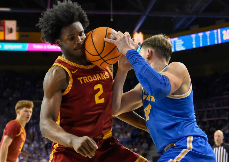 Feb 24, 2026; Los Angeles, California, USA; UCLA Bruins forward Tyler Bilodeau (34) collides with Southern California Trojans forward Ezra Ausar (2) as he drives the baseline during the second half at Pauley Pavilion presented by Wescom Financial. Mandatory Credit: Robert Hanashiro-Imagn Images