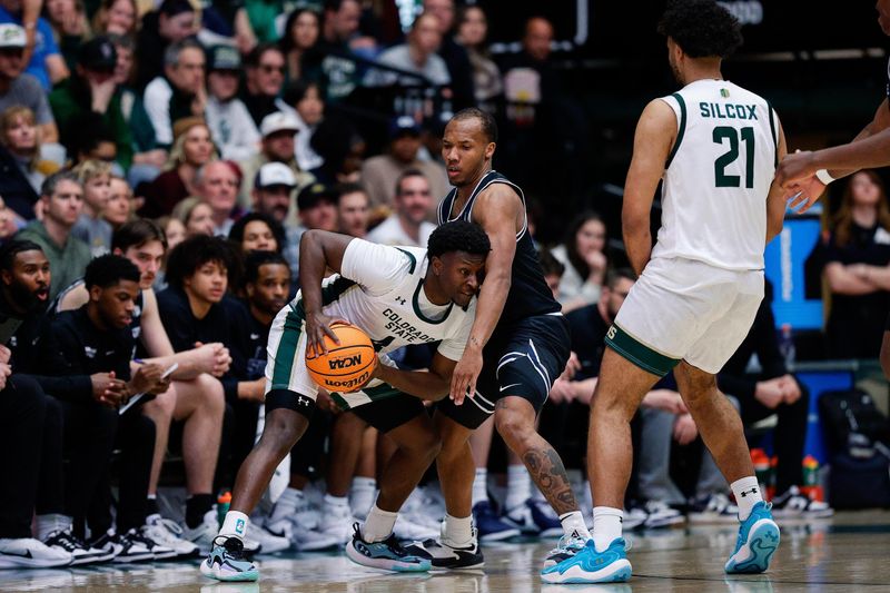 Feb 17, 2024; Fort Collins, Colorado, USA; Colorado State Rams guard Isaiah Stevens (4) controls the ball as Utah State Aggies guard Darius Brown II (10) guards as guard Rashaan Mbemba (21) defends in the first half at Moby Arena. Mandatory Credit: Isaiah J. Downing-USA TODAY Sports