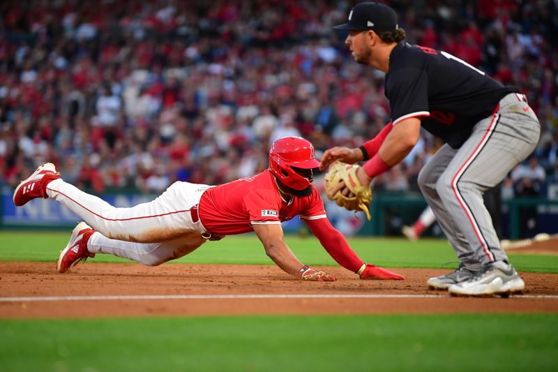 Apr 27, 2024; Anaheim, California, USA; Los Angeles Angels third baseman Luis Rengifo (2) reaches third against Minnesota Twins third baseman Kyle Farmer (12) during the second inning at Angel Stadium. Mandatory Credit: Gary A. Vasquez-USA TODAY Sports