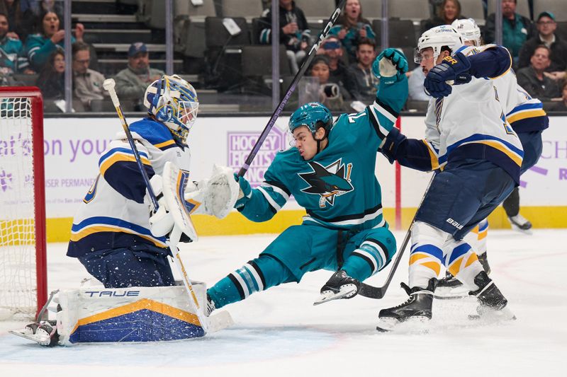 Nov 16, 2023; San Jose, California, USA; St. Louis Blues defenseman Justin Faulk (72) checks San Jose Sharks left wing Danil Gushchin (75) off his feet in front of St. Louis Blues goaltender Jordan Binnington (50) during the second period at SAP Center at San Jose. Mandatory Credit: Robert Edwards-USA TODAY Sports