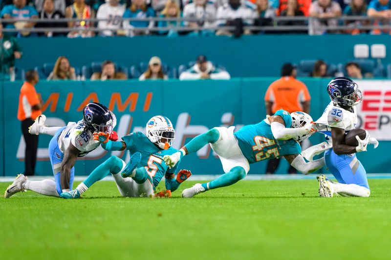 Tennessee Titans running back Tyjae Spears (32) runs with the ball and is tackled by Miami Dolphins linebacker Duke Riley (45) along with Tennessee Titans tight end Chig Okonkwo (85) and Miami Dolphins cornerback Jalen Ramsey (5) during an NFL football game Monday, Dec. 12, 2023, in Miami Gardens, Fla. (AP Photo/Doug Murray)