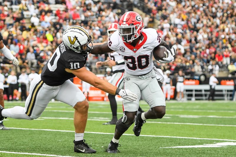 Oct 14, 2023; Nashville, Tennessee, USA;  Georgia Bulldogs running back Daijun Edwards (30) stiff arms Vanderbilt Commodores linebacker Langston Patterson (10) during the first half at FirstBank Stadium. Mandatory Credit: Steve Roberts-USA TODAY Sports