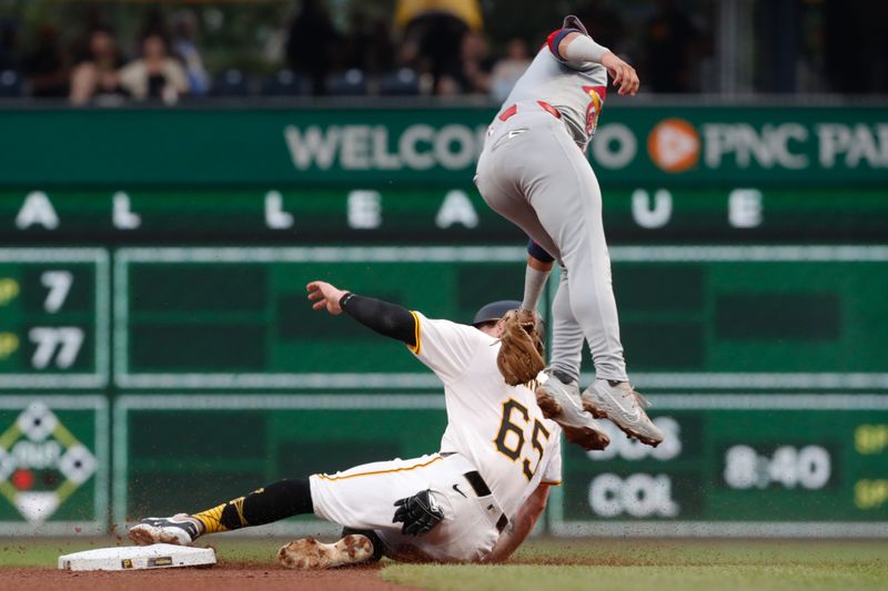 Jul 22, 2024; Pittsburgh, Pennsylvania, USA;  Pittsburgh Pirates center fielder Jack Suwinski (65) steals second base as St. Louis Cardinals shortstop Masyn Winn (0) attempts a tag during the fourth inning at PNC Park. Mandatory Credit: Charles LeClaire-USA TODAY Sports