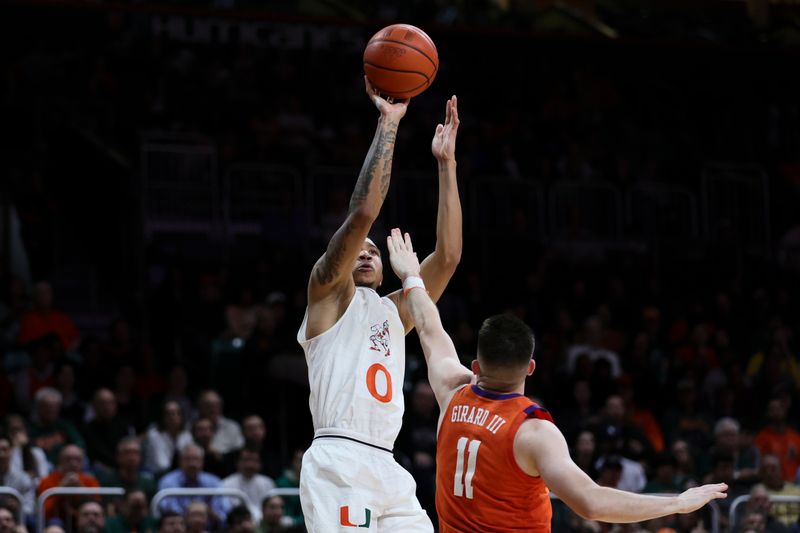 Jan 3, 2024; Coral Gables, Florida, USA; Miami Hurricanes guard Matthew Cleveland (0) shoots the basketball over Clemson Tigers guard Joseph Girard III (11) during the second half at Watsco Center. Mandatory Credit: Sam Navarro-USA TODAY Sports