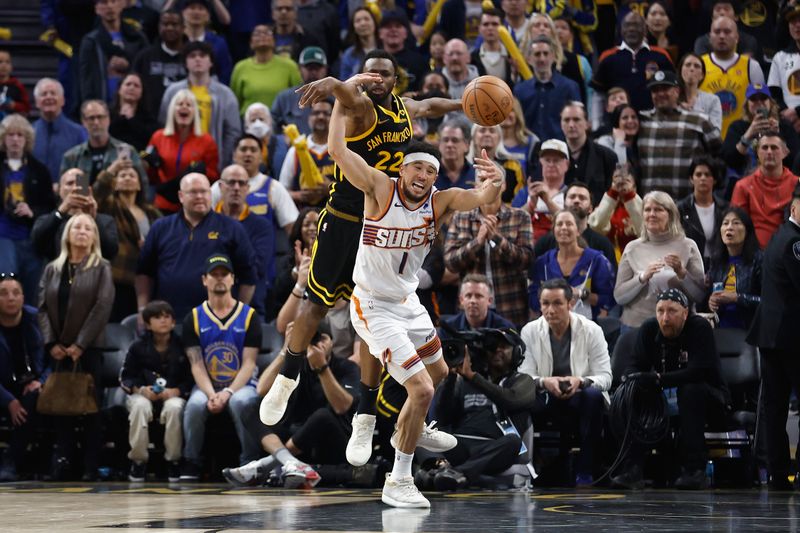 SAN FRANCISCO, CALIFORNIA - FEBRUARY 10: Devin Booker #1 of the Phoenix Suns is fouled by Andrew Wiggins #22 of the Golden State Warriors late in the fourth quarter at Chase Center on February 10, 2024 in San Francisco, California. NOTE TO USER: User expressly acknowledges and agrees that, by downloading and or using this photograph, User is consenting to the terms and conditions of the Getty Images License Agreement. (Photo by Lachlan Cunningham/Getty Images)