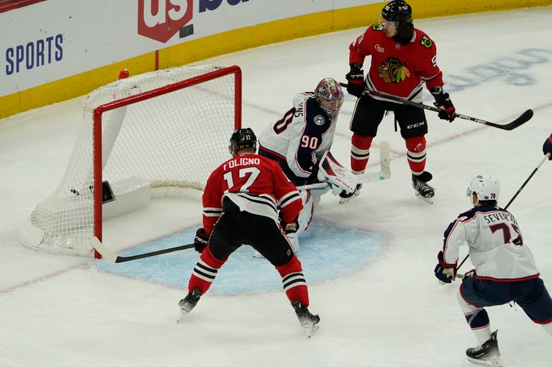 Dec 1, 2024; Chicago, Illinois, USA; Chicago Blackhawks left wing Nick Foligno (17) scores a goal on Columbus Blue Jackets goaltender Elvis Merzlikins (90) during the third period at United Center. Mandatory Credit: David Banks-Imagn Images