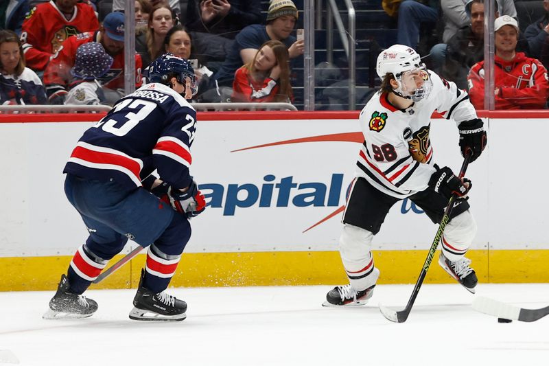 Mar 9, 2024; Washington, District of Columbia, USA; Chicago Blackhawks center Connor Bedard (98) skates with the puck as Washington Capitals center Michael Sgarbossa (23) chases in the second period at Capital One Arena. Mandatory Credit: Geoff Burke-USA TODAY Sports