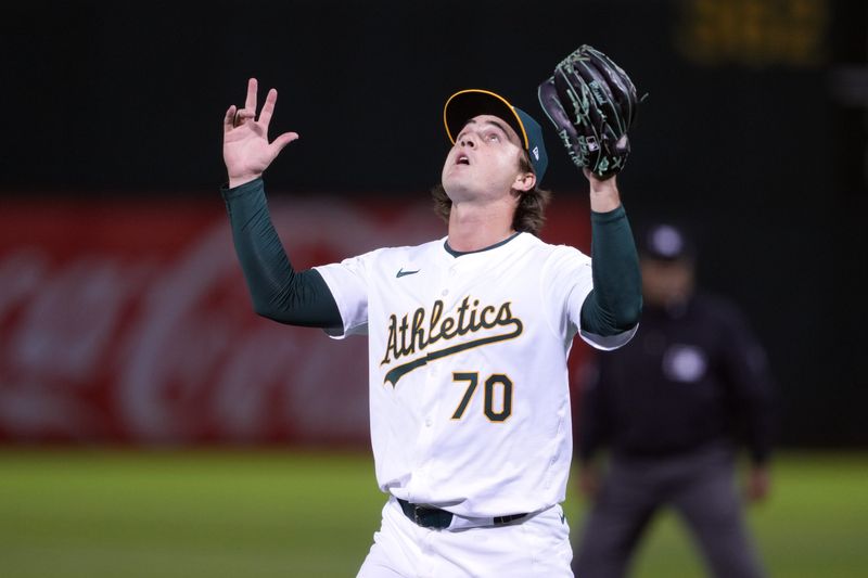 Aug 21, 2024; Oakland, California, USA; Oakland Athletics relief pitcher J.T. Ginn (70) gestures after striking out the side against the Tampa Bay Rays during the eighth inning at Oakland-Alameda County Coliseum. Mandatory Credit: Darren Yamashita-USA TODAY Sports