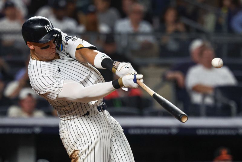 Sep 26, 2024; Bronx, New York, USA; New York Yankees center fielder Aaron Judge (99) hits a two run home run during the seventh inning against the Baltimore Orioles at Yankee Stadium. Mandatory Credit: Vincent Carchietta-Imagn Images