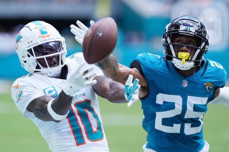 Jacksonville Jaguars cornerback Ronald Darby (25) defends Miami Dolphins wide receiver Tyreek Hill (10) during the first half of an NFL football game, Sunday, Sept. 8, 2024, in Miami Gardens, Fla. (AP Photo/Wilfredo Lee)