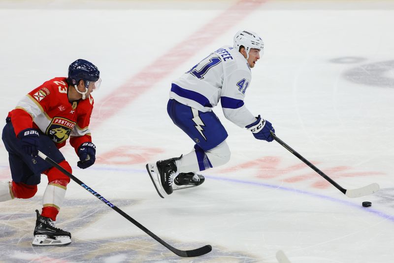 Apr 23, 2024; Sunrise, Florida, USA; Tampa Bay Lightning right wing Mitchell Chaffee (41) moves the puck past Florida Panthers center Carter Verhaeghe (23) during the third period in game two of the first round of the 2024 Stanley Cup Playoffs at Amerant Bank Arena. Mandatory Credit: Sam Navarro-USA TODAY Sports