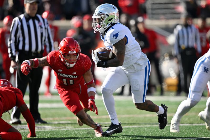 Nov 25, 2023; Louisville, Kentucky, USA;  Kentucky Wildcats running back Ray Davis (1) runs the ball against Louisville Cardinals defensive back Cam'Ron Kelly (11) during the first quarter at L&N Federal Credit Union Stadium. Mandatory Credit: Jamie Rhodes-USA TODAY Sports