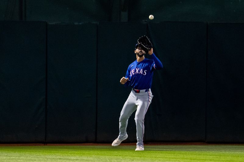 May 6, 2024; Oakland, California, USA; Texas Rangers outfielder Leody Taveras (3) fields a fly ball against the Oakland Athletics during the ninth inning at Oakland-Alameda County Coliseum. Mandatory Credit: Neville E. Guard-USA TODAY Sports