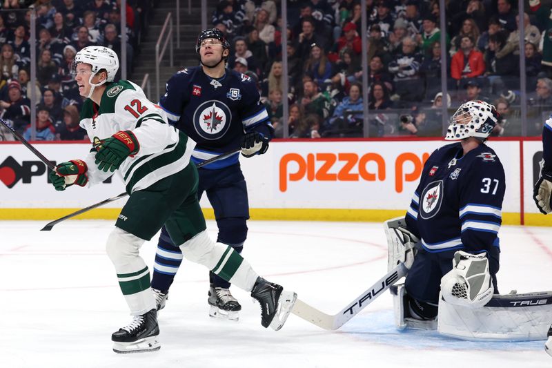 Dec 27, 2025; Winnipeg, Manitoba, CAN; Minnesota Wild left wing Matt Boldy (12) celebrates his goal on Winnipeg Jets goaltender Connor Hellebuyck (37) in the first period at Canada Life Centre. Mandatory Credit: James Carey Lauder-Imagn Images