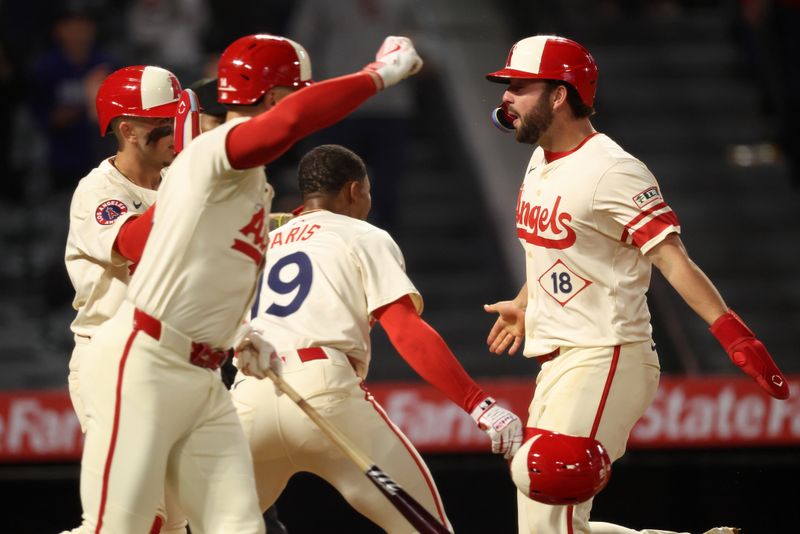 May 7, 2025; Anaheim, California, USA;  Los Angeles Angels first baseman Nolan Schanuel (18, right) scores the winning run on a double by right fielder Jorge Soler (12, not pictured) as teammates celebrate during the ninth inning against the Toronto Blue Jays at Angel Stadium. Mandatory Credit: Kiyoshi Mio-Imagn Images