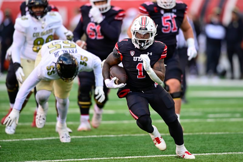 Nov 25, 2023; Salt Lake City, Utah, USA; Utah Utes running back Jaylon Glover (1) evades Colorado Buffaloes defensive lineman Leonard Payne Jr. (55) at Rice-Eccles Stadium. Mandatory Credit: Christopher Creveling-USA TODAY Sports