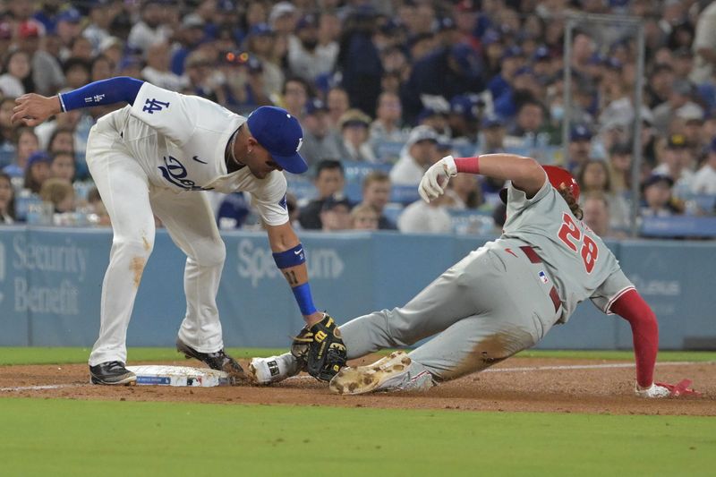 Aug 7, 2024; Los Angeles, California, USA;  Philadelphia Phillies third baseman Alec Bohm (28) is called safe at third by umpire Hunter Wendelstedt (21) on an interference error by Los Angeles Dodgers shortstop Miguel Rojas (11) in the sixth inning at Dodger Stadium. Mandatory Credit: Jayne Kamin-Oncea-USA TODAY Sports