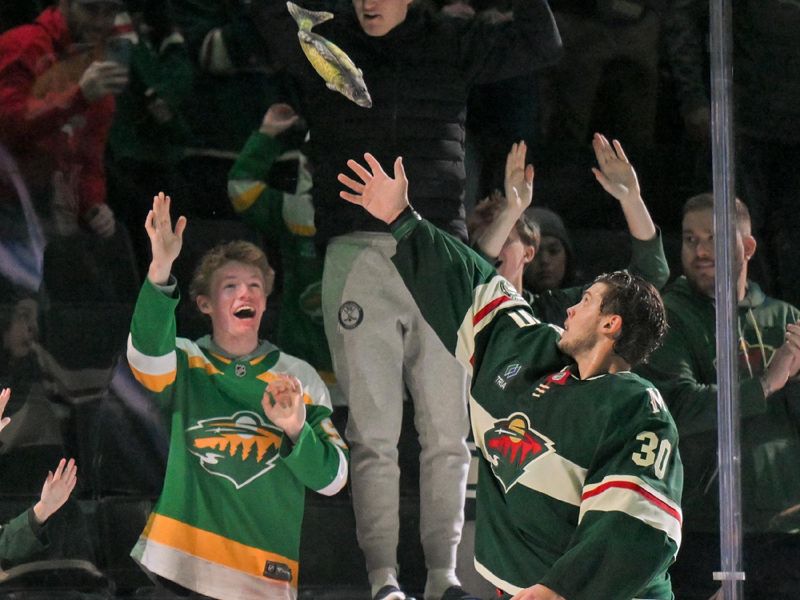 Nov 15, 2025; Saint Paul, Minnesota, USA;  Minnesota Wild goalie Jesper Wallstedt (30) throws an autographed plush fish into the crowd in recognition of being named first star of the game against the Anaheim Ducks at Grand Casino Arena. Mandatory Credit: Nick Wosika-Imagn Images