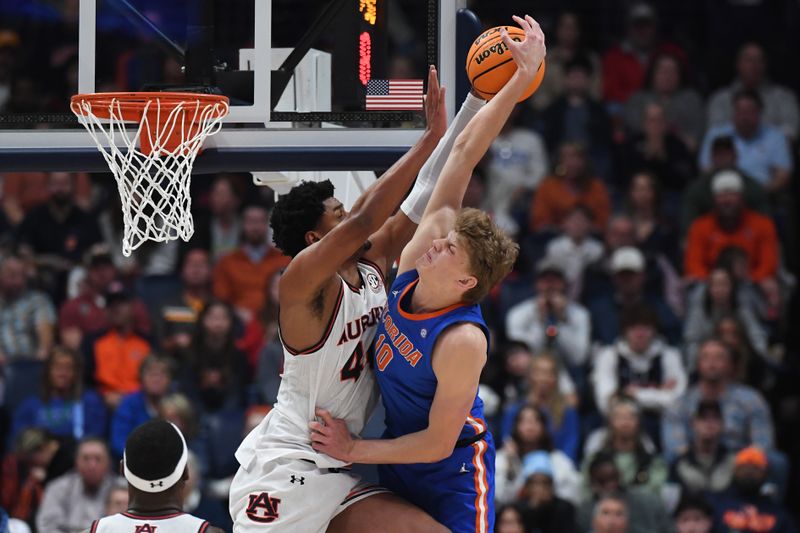 Mar 17, 2024; Nashville, TN, USA; Auburn Tigers center Dylan Cardwell (44) blocks Florida Gators forward Thomas Haugh (10) in the first half in the SEC Tournament championship game at Bridgestone Arena. Mandatory Credit: Christopher Hanewinckel-USA TODAY Sports