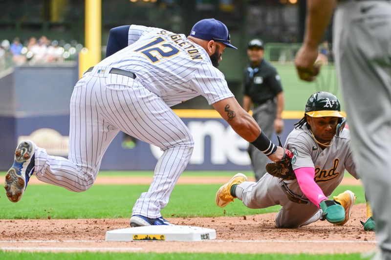 Jun 10, 2023; Milwaukee, Wisconsin, USA; Milwaukee Brewers first baseman Jon Singleton (12) tags out Oakland Athletes center fielder Esteury Ruiz (1) after he was picked off first base in the third inning at American Family Field. Mandatory Credit: Benny Sieu-USA TODAY Sports