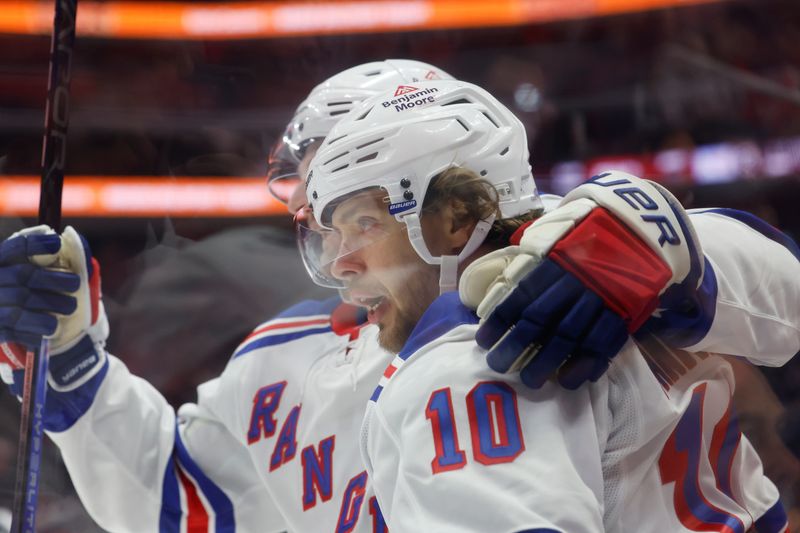 Oct 17, 2024; Detroit, Michigan, USA;  New York Rangers left wing Artemi Panarin (10) receives congratulations from teammates after scoring in the first period against the Detroit Red Wings at Little Caesars Arena. Mandatory Credit: Rick Osentoski-Imagn Images