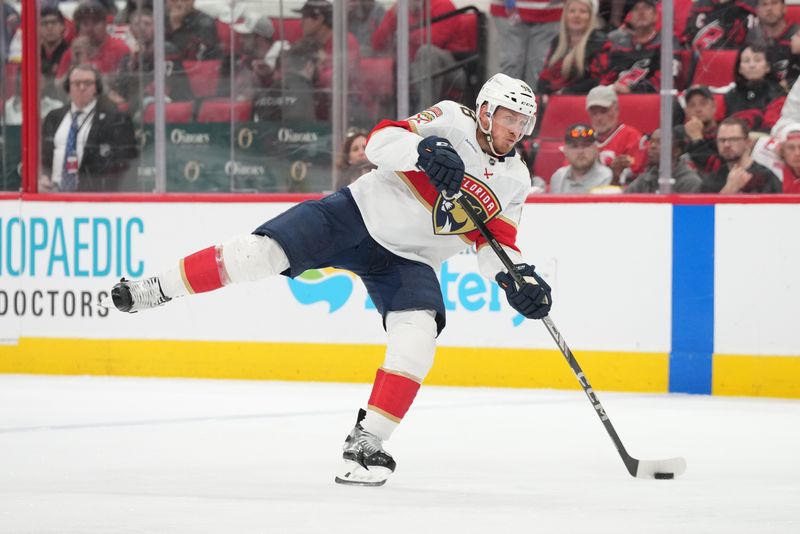 May 20, 2025; Raleigh, North Carolina, USA; Florida Panthers defenseman Nate Schmidt (88) shoots the puck against the Carolina Hurricanes during the second period in game one of the Eastern Conference Final of the 2025 Stanley Cup Playoffs at Lenovo Center. Mandatory Credit: James Guillory-Imagn Images