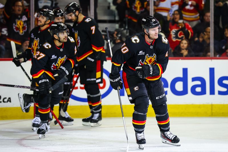 Dec 4, 2025; Calgary, Alberta, CAN; Calgary Flames left wing Jonathan Huberdeau (10) celebrates his goal with teammates against the Minnesota Wild during the second period at Scotiabank Saddledome. Mandatory Credit: Sergei Belski-Imagn Images