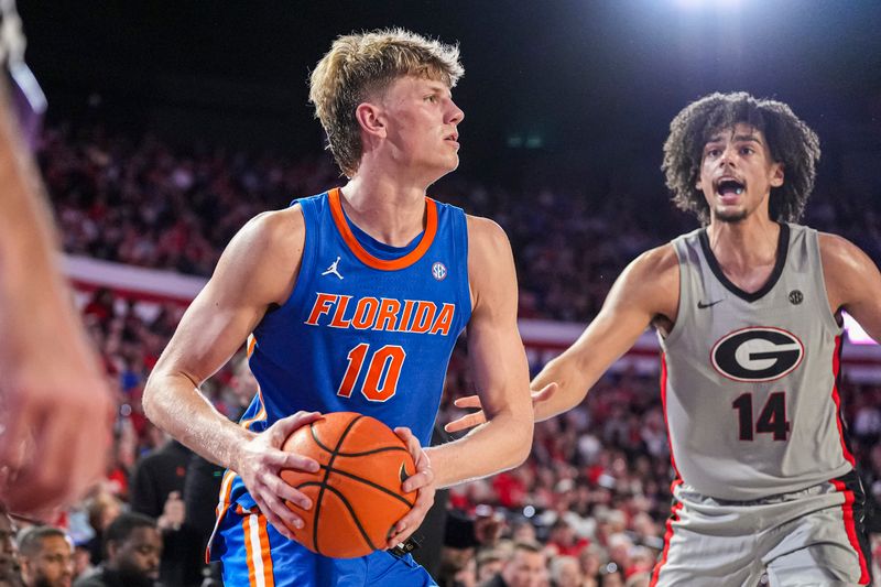 Feb 25, 2025; Athens, Georgia, USA; Florida Gators forward Thomas Haugh (10) handles the ball against Georgia Bulldogs forward Asa Newell (14) during the first half at Stegeman Coliseum. Mandatory Credit: Dale Zanine-Imagn Images