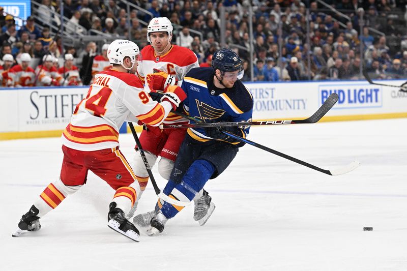 Jan 16, 2025; St. Louis, Missouri, USA; Calgary Flames defenseman Brayden Pachal (94) and center Mikael Backlund (11) battle St. Louis Blues center Radek Faksa (12) for the puck in the second period at Enterprise Center. Mandatory Credit: Joe Puetz-Imagn Images