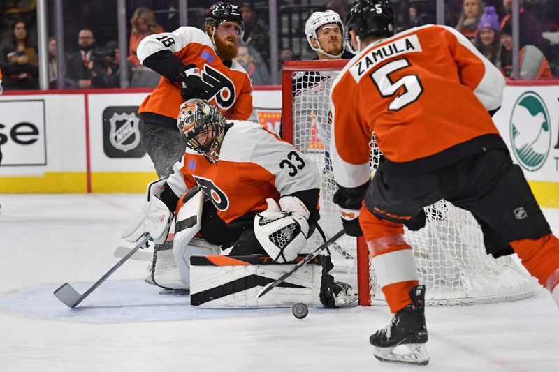 Jan 4, 2024; Philadelphia, Pennsylvania, USA; Philadelphia Flyers goaltender Samuel Ersson (33) makes a save as defenseman Egor Zamula (5) clears the puck against the Columbus Blue Jackets during the second period at Wells Fargo Center. Mandatory Credit: Eric Hartline-USA TODAY Sports