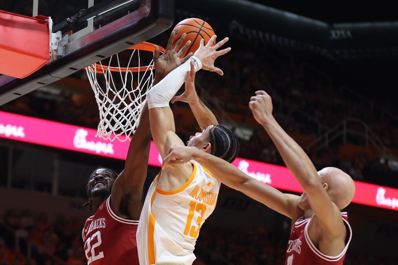 Feb 28, 2023; Knoxville, Tennessee, USA; Tennessee Volunteers forward Olivier Nkamhoua (13) is fouled by Arkansas Razorbacks forward Makhel Mitchell (22) during the first half at Thompson-Boling Arena. Mandatory Credit: Randy Sartin-USA TODAY Sports