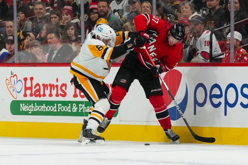 Dec 18, 2022; Raleigh, North Carolina, USA;  Pittsburgh Penguins defenseman Brian Dumoulin (8) checks Carolina Hurricanes right wing Andrei Svechnikov (37) during the second period at PNC Arena. Mandatory Credit: James Guillory-USA TODAY Sports