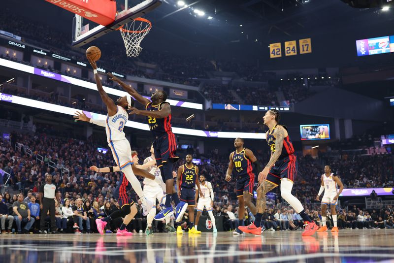 SAN FRANCISCO, CALIFORNIA - NOVEMBER 27: Shai Gilgeous-Alexander #2 of the Oklahoma City Thunder takes a shot against Draymond Green #23 of the Golden State Warriors during the first half at Chase Center on November 27, 2024 in San Francisco, California. NOTE TO USER: User expressly acknowledges and agrees that, by downloading and or using this photograph, User is consenting to the terms and conditions of the Getty Images License Agreement (Photo by Ezra Shaw/Getty Images)