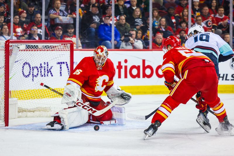 Mar 4, 2024; Calgary, Alberta, CAN; Calgary Flames goaltender Jacob Markstrom (25) makes a save against Seattle Kraken left wing Jared McCann (19) during the first period at Scotiabank Saddledome. Mandatory Credit: Sergei Belski-USA TODAY Sports