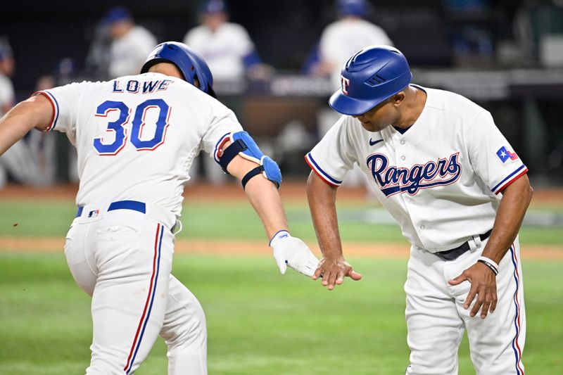 Oct 10, 2023; Arlington, Texas, USA; Texas Rangers first baseman Nathaniel Lowe (30) celebrates with third base coach Tony Beasley (27) after hitting a solo home run in the sixth inning against the Baltimore Orioles during game three of the ALDS for the 2023 MLB playoffs at Globe Life Field. Mandatory Credit: Jerome Miron-USA TODAY Sports