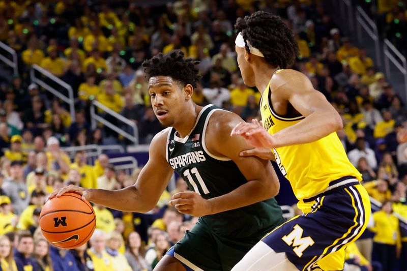 Feb 18, 2023; Ann Arbor, Michigan, USA;  Michigan State Spartans guard A.J. Hoggard (11) dribbles the ball against Michigan Wolverines guard Kobe Bufkin (2) in the second half at Crisler Center. Mandatory Credit: Rick Osentoski-USA TODAY Sports