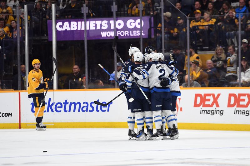 Apr 9, 2024; Nashville, Tennessee, USA; Winnipeg Jets players celebrate after a goal by defenseman Dylan DeMelo (2) during the first period against the Nashville Predators at Bridgestone Arena. Mandatory Credit: Christopher Hanewinckel-USA TODAY Sports