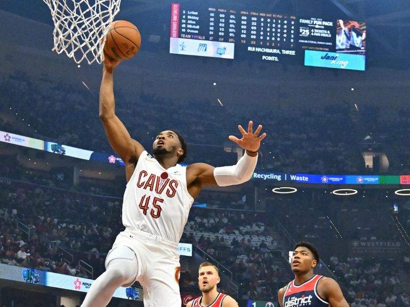 CLEVELAND, OHIO - OCTOBER 23: Donovan Mitchell #45 of the Cleveland Cavaliers dunks past Kristaps Porzingis #6 and Rui Hachimura #8 of the Washington Wizards during the first quarter  at Rocket Mortgage Fieldhouse on October 23, 2022 in Cleveland, Ohio. NOTE TO USER: User expressly acknowledges and agrees that, by downloading and or using this photograph, User is consenting to the terms and conditions of the Getty Images License Agreement. (Photo by Jason Miller/Getty Images)